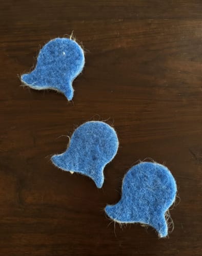 Customer's three blue Laundry Pet Hair Removal Fish on a dark wood surface with collected pet hair visible.