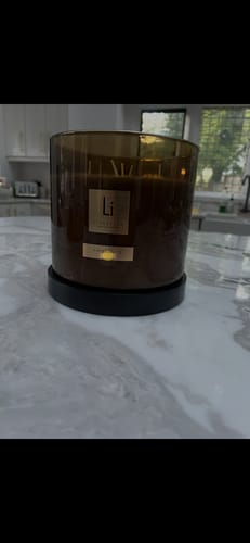 Customer's large Amber Fie XXL candle in a dark jar, displayed on a marble countertop at home.
