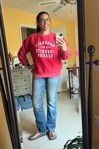 Reviewer takes a mirror selfie showing the fit of the red 'Baseball Is My Favorite Season' corded sweatshirt.