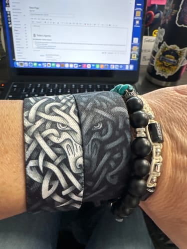 Reviewer wearing both Wolfpack bracelets on one wrist, showing how the two halves form a complete wolf face.