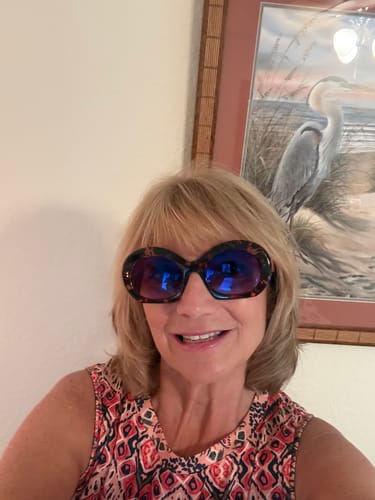 Reviewer smiling while wearing the large, tortoiseshell Sunglass Progressive Readers indoors.