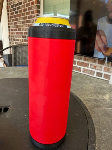 Customer's red and black Double Tactical Reload Can Holder sitting on an outdoor table with a can inside.