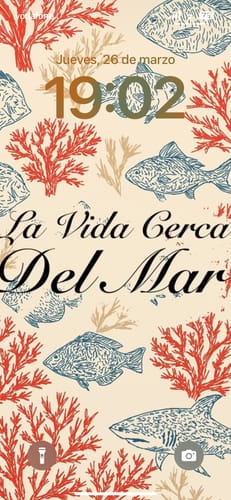 Reviewer's phone lock screen showing the CORAL WALLPAPER with a vintage design of fish and coral.