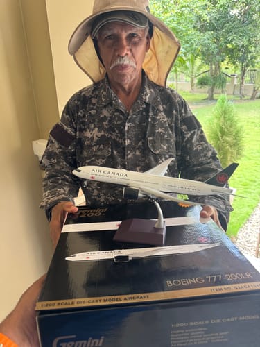 Customer holding the assembled Air Canada 777-200LR model airplane and its original box.