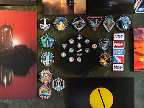 Customer's Starship pin collection on the hexagonal display, mounted on a wall as part of a larger space-themed collection.
