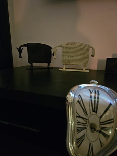 Reviewer's white Cow Figurine displayed on a dark surface with another figurine from their collection.