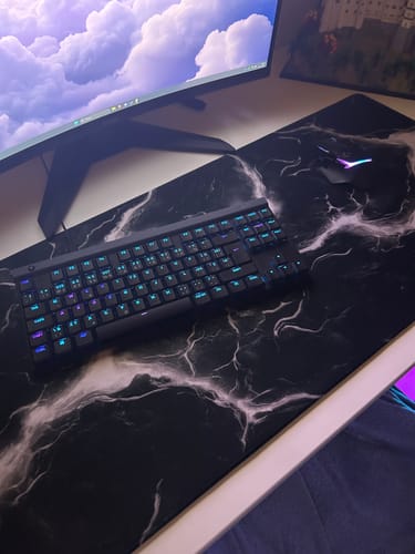 Customer's Molten Lava Black mousepad on a white desk with a backlit keyboard and mouse on top.