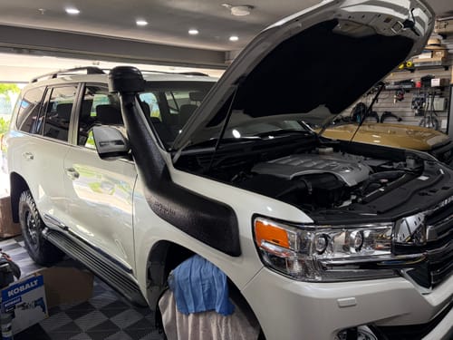 Customer's white SUV in a garage with its hood open and a new snorkel installed, as mentioned in their review.