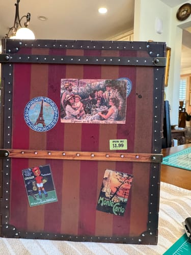 Packaging for the Eternal Midnight Paris Book Nook Kit, styled as a vintage striped trunk with travel stickers.