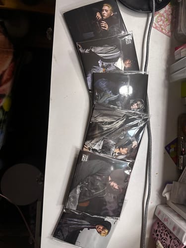 Customer's P1HARMONY photobook set fanned out on a desk, still sealed in original plastic wrap.