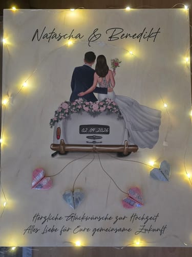 Ein Kunde zeigt die bedruckte Kiste des Leonardo Hochzeitssets. Sie zeigt ein Hochzeitsauto-Motiv mit personalisierten Namen und Datum.