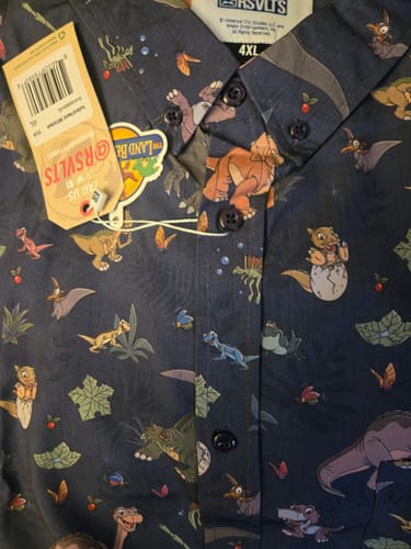 Customer's close-up of the 'Prehistoric Pals' shirt, showing the colorful Land Before Time character pattern on dark fabric.
