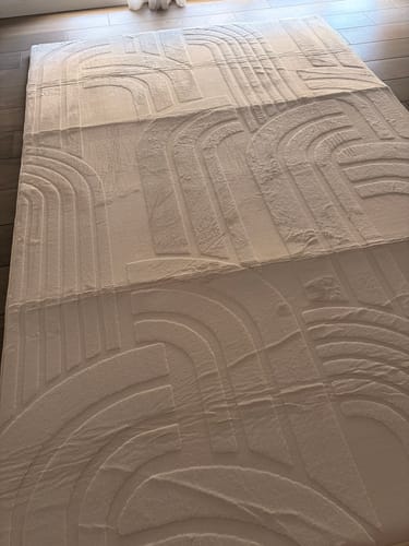 Customer's Mellow Mat Cloud Haven 3D rug in Vanilla Cream, laid out on a wooden floor to showcase its carved pattern.