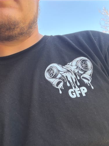 Close-up of a customer wearing the black TWINS TEE, showing the twin-turbo graphic on the chest.