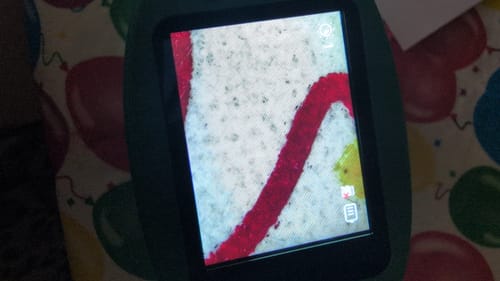 Kunde zeigt eine vergrößerte rote Linie auf dem Bildschirm des Edubini Abenteuer-Mikroskops.