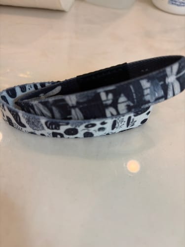 Close-up of a customer's reversible Mystery Club+ bracelet on a countertop, showing the two different black-and-white patterns.