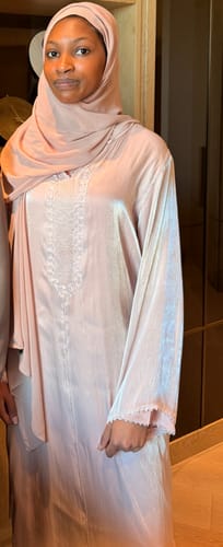 Reviewer wearing the shiny, lilac Jellaba Maha, showing the embroidered neckline and relaxed fit.