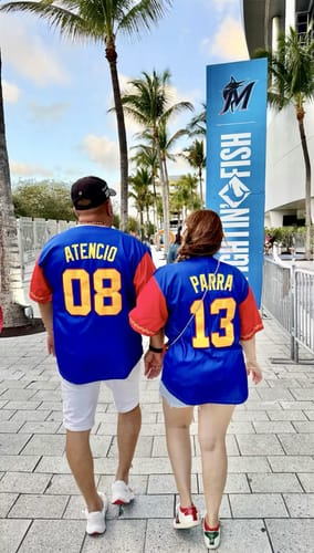 Reviewers wearing blue Venezuela Heritage Custom Baseball Jerseys from behind, showing their personalized names and numbers.