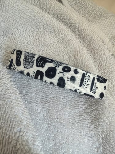 Customer's Let It Go Bracelet with a black and white abstract pattern resting on a towel.