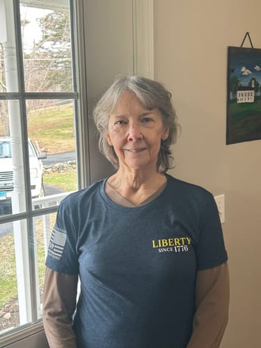 Reviewer wearing the dark '250 Years of Heroes' t-shirt over a long-sleeved shirt indoors.