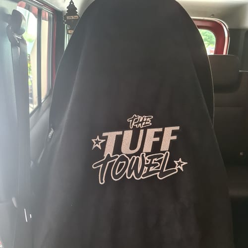 Customer's black Waterproof Car Towel Seat Cover fitted over a car seat, showing the prominent logo.