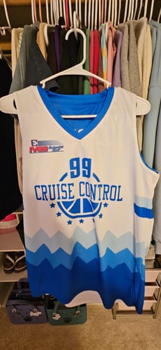 Customer's custom white basketball jersey with blue 'CRUISE CONTROL' text and the number 99 hanging in a closet.