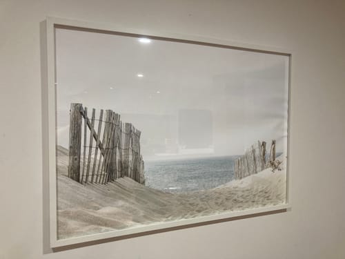 Customer's damaged 'Path to the Sea Art Print' in a white frame hung on a wall.