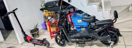 Cliente muestra la Bicicleta Eléctrica Negra Kiwo completamente ensamblada en un espacio interior.