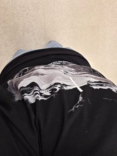 Reviewer's overhead view of the back of the black oversized 'Shadow of Death' t-shirt.