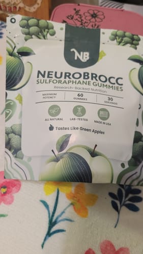 Customer's white pouch of NeuroBrocc Sulforaphane Gummies resting on a floral surface.