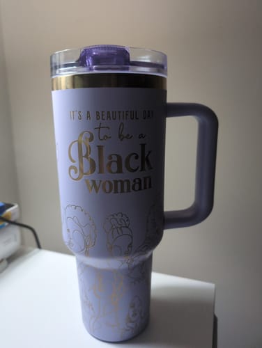 Customer's lavender tumbler with the gold affirmation, 'It's a Beautiful Day to be a Black Woman', on a desk.