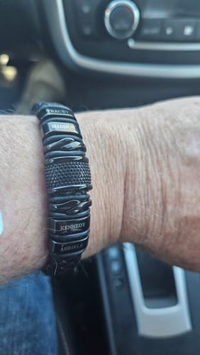 Reviewer wearing the personalized black bracelet on their wrist, showing the custom name engravings.