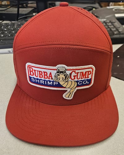Reviewer's customized red watersport hat with a large "Bubba Gump Shrimp Co." patch on the front.