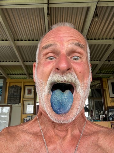 Reviewer sticking his tongue out, which is stained bright blue after taking the Just Blue™ troche.