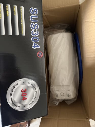 Reviewer unboxing the Glacier Fresh U06 water filter, showing the unit in plastic next to its packaging.