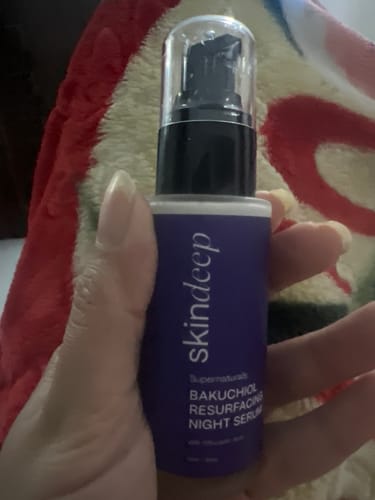 Customer holding the purple bottle of Bakuchiol Resurfacing Night Serum.