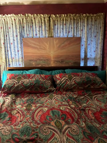 Customer's Angelic Realm Wall Art with calming, peaceful colors shown hanging on a wall above a bed.