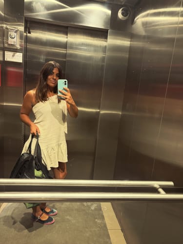 Clienta luciendo el VESTIDO AGATHA arena de un hombro en un selfie de ascensor.