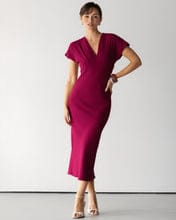 Customer wearing the burgundy Juliette V Neck Dress, showing its v-neck, cap sleeves, and body-hugging fit.