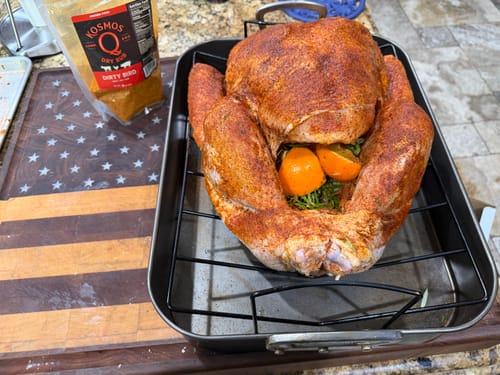 Reviewer's raw turkey seasoned with Dirty Bird Rub in a roasting pan, with the product packaging visible.