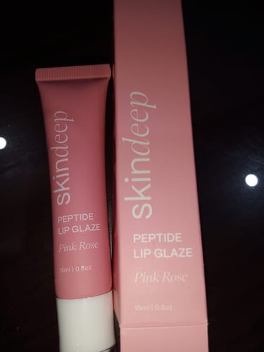 Customer's Peptide Lip Glaze in the Pink Rose shade, shown with its pink product box.
