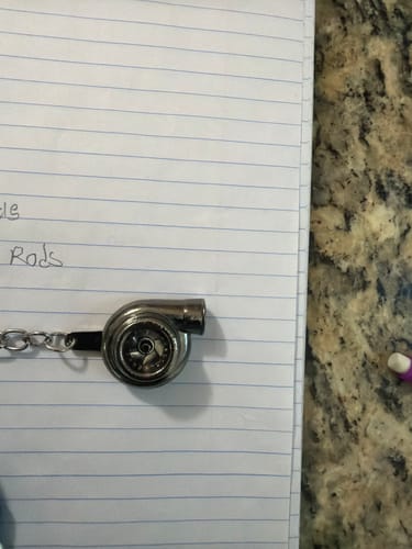Customer's metallic Turbo Keychain lying on a piece of lined notebook paper.