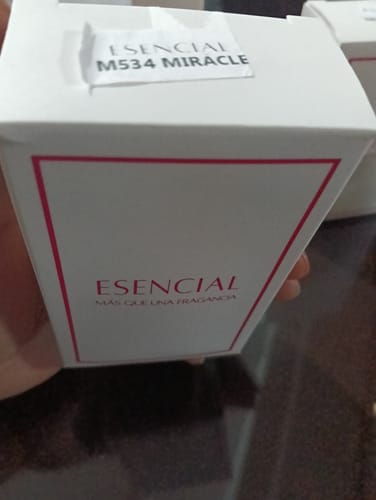 Cliente sosteniendo la caja blanca del perfume M534 Inspirado en: Miracle.