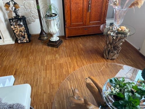 Rezensent zeigt den rustikalen REGINA Wurzeltisch als Beistelltisch in einem Wohnzimmer.