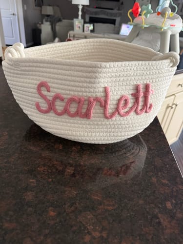 Customer's personalized woven basket, shown with the name 'Scarlett' in pink script on a countertop.