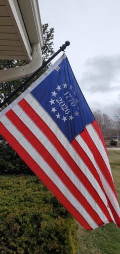 Customer's 1776 to 2026 Betsy Ross flag waving from a flagpole attached to a house.