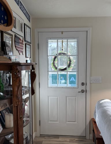 Customer's white door with the Clear 9 Lite Glass and Frame Kit installed, brightening a living room with added daylight.
