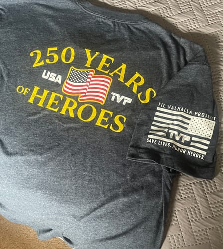 Customer's dark gray '250 Years of Heroes' t-shirt laid flat, showing the yellow back graphic and sleeve design.