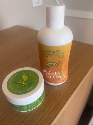 Anmelderens Vossabia kroppsbalsam og "Skogen på kroppen"-kroppssåpe fra luksuspakken på et trebord.