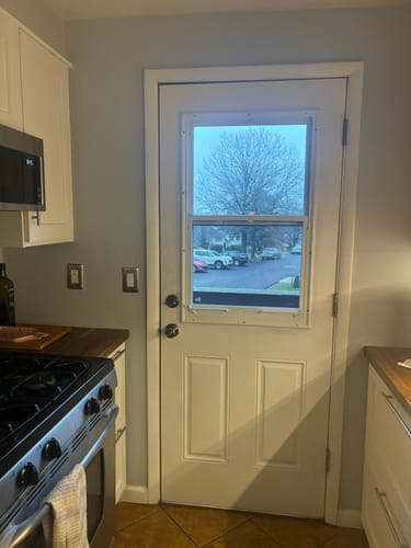 Customer's new Venting 1 Lite Glass and Frame Kit installed on a white kitchen door, letting in more light.